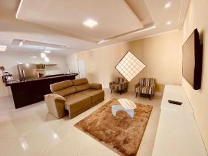 a living room with a couch and a table at Casa em flecheiras com piscina in Flecheiras