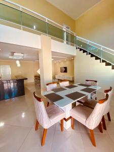 a dining room with a table and chairs and a staircase at Casa em flecheiras com piscina in Flecheiras