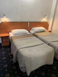 a hotel room with two beds and a table at Hotel Liberty in Paris