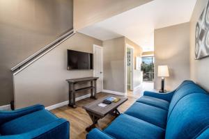 a living room with a blue couch and a table at Waterside Suites and Marina in Key Largo