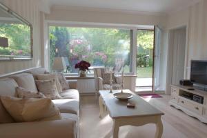 a living room with a white couch and a tv at Timmendorf - Strandnah in Timmendorfer Strand