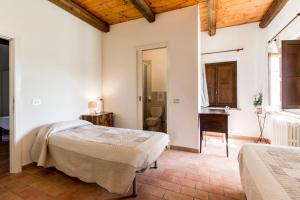 a bedroom with two beds and a desk and a bathroom at Country House La Fattoria Di Paolo in Treia +42 photos