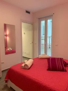 sypialnia z dużym czerwonym łóżkiem z ręcznikami w obiekcie Casa Macallè - Letojanni - Taormina w mieście Letojanni