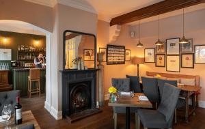 a restaurant with a fireplace and a table and chairs at The Five Arrows Hotel in Waddesdon