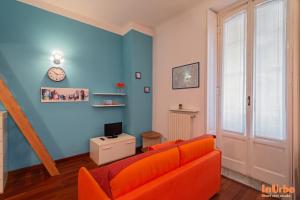 ミラノにあるInUrbe - Navigli Studioのリビングルーム(オレンジ色のソファ、時計付)