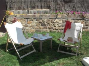 two chairs and a table in the grass with a table with cups at Rollarthouse in Rollamienta +4 photos
