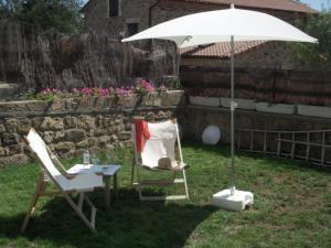 two chairs and an umbrella in a yard at Rollarthouse in Rollamienta