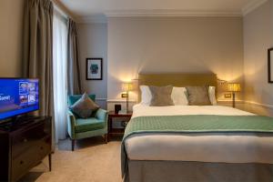 Habitación de hotel con cama y TV en Dukes London en Londres