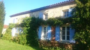 a house with blue doors and ivy at Studio jangadi in Reignac