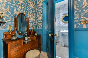 een badkamer met een spiegel en een houten dressoir bij Jazz House in Derry Londonderry