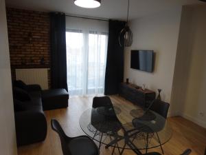 salon ze szklanym stołem i krzesłami w obiekcie Black&White Apartment Bis - Małe Garbary 8 w Poznaniu