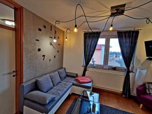a living room with a couch and a window at FACTORY - SELF check in in Osijek