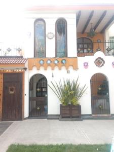ein weißes Gebäude mit zwei Türen und einer Veranda in der Unterkunft Casa Mexicana Patio in Mexiko-Stadt