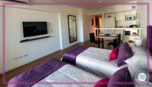 een hotelkamer met twee bedden en een televisie bij Medrano Kind in Buenos Aires +30 foto's
