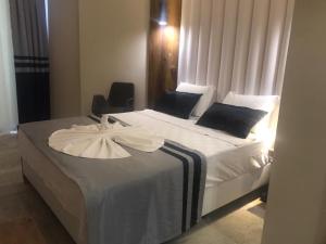 1 dormitorio con 1 cama con colcha blanca y silla en Sette Serenity Hotel, en Alanya