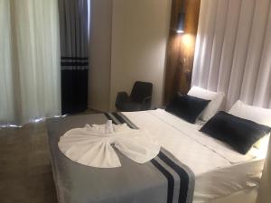 um quarto de hotel com uma cama com um vestido em Sette Serenity Hotel em Alanya