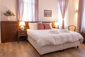 a bedroom with a large white bed with two lamps at Seven Cafe and Hotel in Pogradec