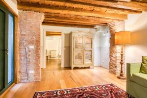 un soggiorno con pavimenti in legno e un muro di mattoni di Boutique Hotel Scalzi - Adults Only a Verona