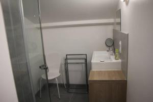 uma casa de banho com um lavatório e uma cabina de duche em vidro. em Azur de Touraine em Monts