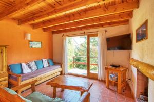 a living room with a couch and a large window at Punto Bariloche in San Carlos de Bariloche