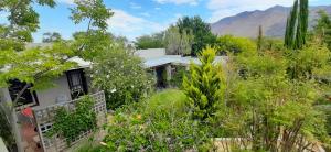 a house in the middle of a garden at Abigail's Garden Cottage in Montagu