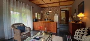 a living room with a chair and a table at Abigail's Garden Cottage in Montagu