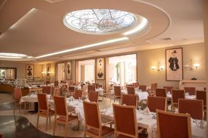 a dining room with tables and chairs and a stained glass window at Rodos Palace Hotel in Ixia