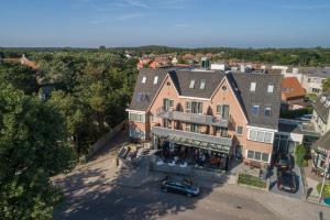 una vista aérea de una casa con un coche aparcado delante en Hotel Kogerstaete Texel en De Koog