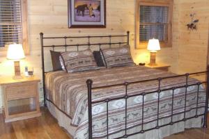 a bedroom with a large bed with two lamps at Cherokee Dream Mountain Lodge in Epworth
