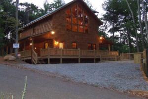 a large log cabin with a large porch in the woods at Cherokee Dream Mountain Lodge in Epworth