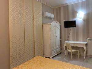 een slaapkamer met een bed, een bureau en een televisie bij Albergo La Villetta in Sarzana