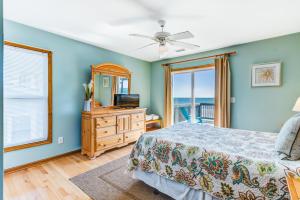 Schlafzimmer mit einem Bett, einem TV und einem Fenster in der Unterkunft Turtle Watch II in Folly Beach