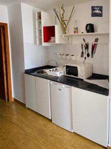 a white kitchen with a sink and a microwave at Giulia Puerto del Carmen in Puerto del Carmen