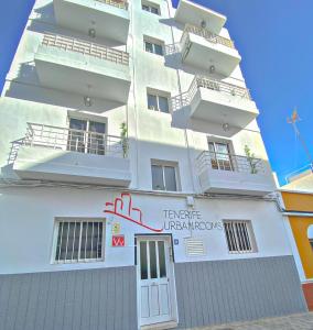 un bâtiment blanc avec un panneau sur son côté dans l'établissement TENERIFE URBAN ROOMS, à Santa Cruz de Tenerife