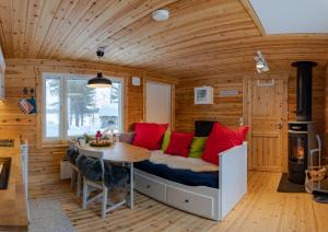 een kamer met een bed met rode kussens en een tafel bij Hirsi - The White Blue Wilderness Lodge in Kaamanen