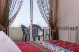 a bedroom with a bed and a view of a balcony at House Bay in Figueira da Foz