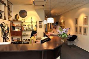 a man and a woman standing at a counter in a store at Berlin ART Hotel in Gyumri