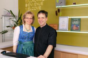 Ein Mann und eine Frau stehen vor einem Computer in der Unterkunft Hotel Adler in Freudenstadt