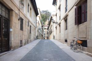 an empty alley with a bike parked next to buildings at Bell Tower with AC by Santiago in San Sebastián