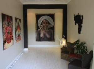 een hal met een schilderij van een vrouw aan de muur bij Lucky Bean Guesthouse in Johannesburg