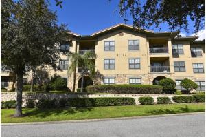 un gran edificio de apartamentos con un árbol delante en Two-Bedroom Townhome Kissimmee, en Orlando