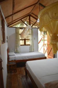 A bed or beds in a room at Hosteria Cabanas Itapoa