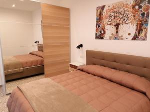 a bedroom with two beds and a painting on the wall at La Casa di Pitti in Anacapri