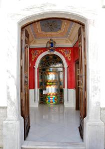 een toegang tot een kamer met rode muren en een kroonluchter bij El Zaguán de la Plata in Fuente de Cantos