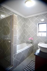 Un baño con ducha, bañera y lavabo. en Green Haven Apartments, en Ezulwini 32 fotos más