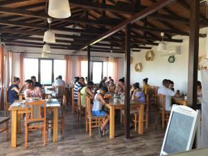 a group of people sitting at tables in a restaurant at Casa de la Corbu in Corbu
