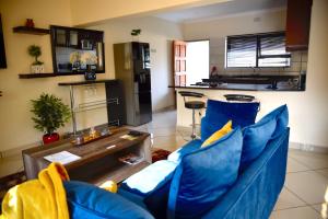 a living room with a blue couch and a table at Green Haven Apartments in Ezulwini