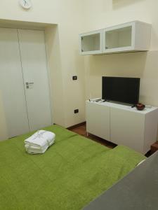 a room with a bed with a television and a green blanket at GISELLE in Naples