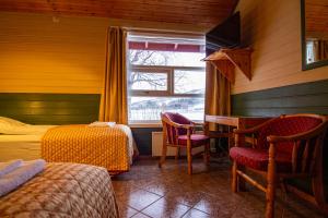 a room with two beds and a desk and a window at Tysfjord Hotel in Storjord I Tysfjord
