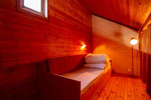 a small room with a bed in a wooden wall at Tysfjord Hotel in Storjord I Tysfjord